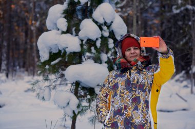 Kış ormanında selfie. Adam ve kadın bir köknar ağacının yanında fotoğraflanmış..