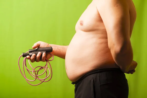 Der Mann mit dem Bauch hält den Apparat in der Hand. Übergewicht. — Stockfoto