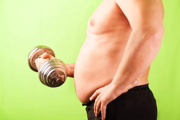 The man with the stomach holds the apparatus in hand. Excess weight. — 图库照片