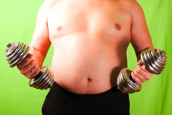 The man with the stomach holds the apparatus in hand. Excess weight. — 图库照片