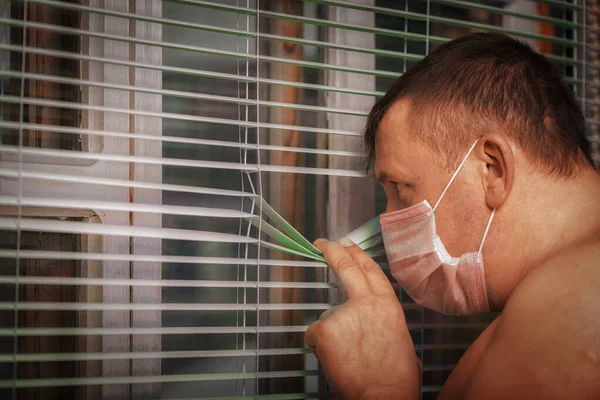 Man Medical Mask Forced Isolation Looks Out Window Blinds Strict Stock Photo