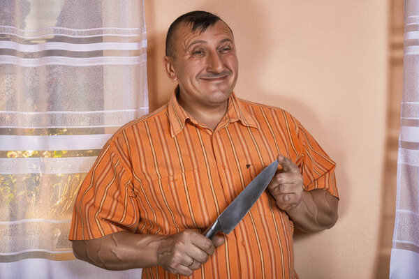 Portrait of the person holding cold weapon in a hand. The look expresses inadequate behavior. Plans bad intentions. 