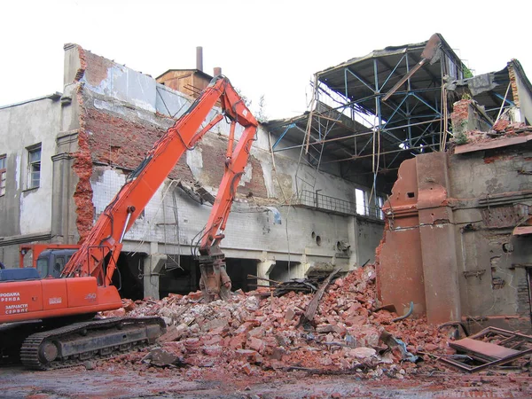 Excavator breaks a house. House demolition.