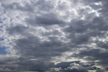 Gri ve beyaz bulutlar ve güneş ışığıyla akşam kontrast gökyüzü. Dramatik gökyüzü