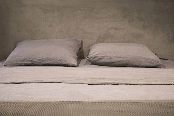 Bed in loft style with grey pillows and velvet headboard