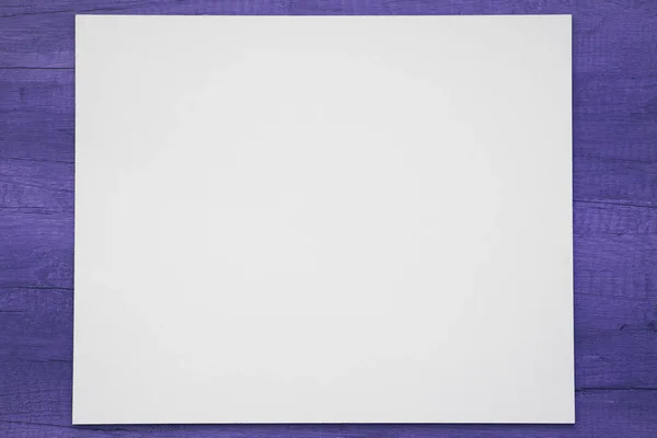 Λευκή μακέτα επάνω σε ένα βαμμένο σε μπλε ξύλινο φόντο. χρώμα του έτους 2020 κλασικό μπλε pantone — Φωτογραφία Αρχείου