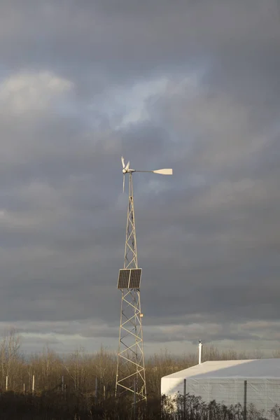 들판에서 구름낀 하늘 아래있는 태양 전 지판 과 풍력 터빈. — 스톡 사진