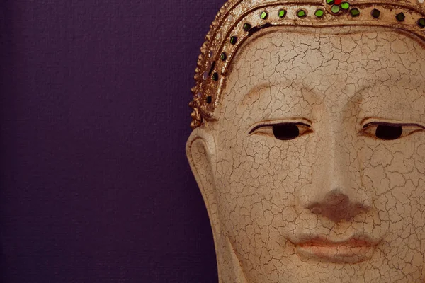 Closeup of buddha face image on dark violet background Royalty Free Stock Photos