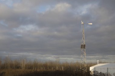 Bulutlu gökyüzüne karşı rüzgar türbinleri ve güneş panelleri. alternatif elektrik üretiliyor.