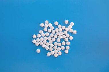 Mavi arka planda bir sürü beyaz yuvarlak tablet.