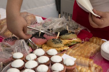 İnsan eli sandviç ve abur cubur alır.