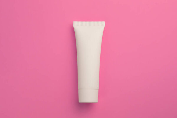 Natural cosmetic in white tube in the middle of pink background