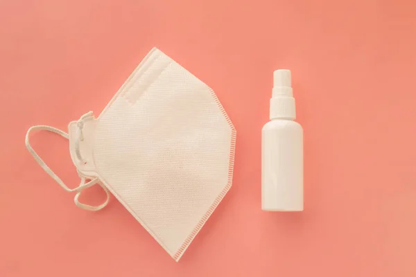 Spray antibacteriano desinfectante en frasco blanco y máscara protectora para la prevención de infecciones . — Foto de Stock