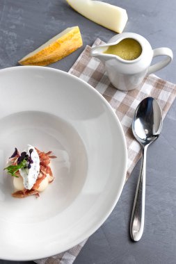 Nane, proshuto ve salatalık ile kavun çorbası. Beyaz plaka, tureen, gri arka plan üzerinde kaşık