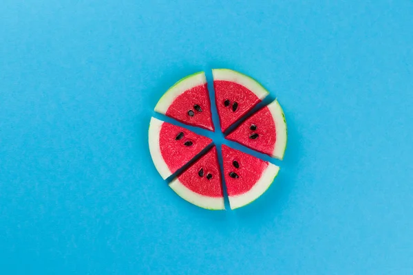 Minimal summer concept made with watermelon fruit slices and black seeds on bright light blue background. Trendy Summer pattern. Top view