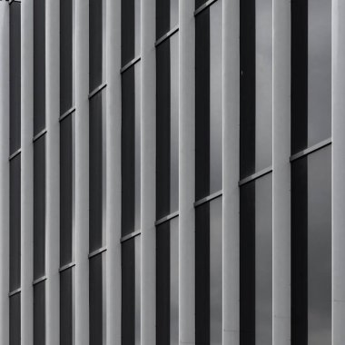 Modern ev duvarı, geometrik çizgiler ve desenler. Binanın dikey çizgili dış cephesinin metal detayları