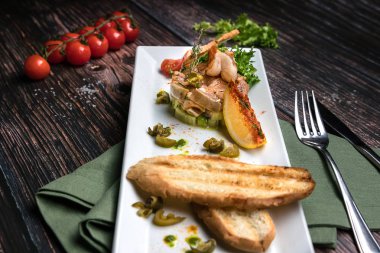 Karides, portakal, kiraz domates, marul, salatalık ve ahşap koyu arka plan üzerinde kruton ile Somon ceviche yakın. Rustik tarzda sağlıklı gıda konsepti