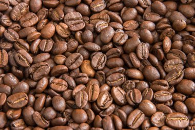 Kavrulmuş kahve çekirdeği dokusu ve küçük bir bokeh. Kahverengi kahve çekirdekleri fotokopi alanı ile yakın plan fotoğraf