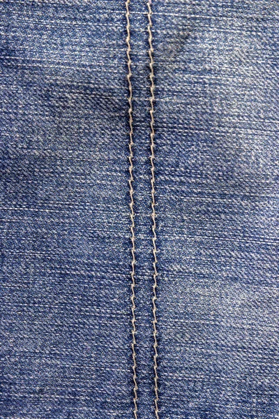 Вид зверху на джинсову текстуру зі швом. Полотно джинсовий фон синього кольору з деталями — стокове фото