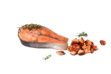 Yiyecek bileşimi, ızgara somon bifteği, küçük parçalara ayrılmış et, beyaz arka planda izole edilmiş biberiye ve karabiber.