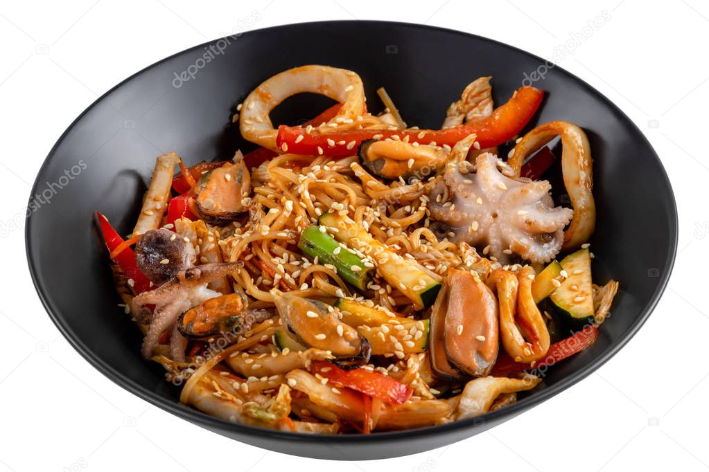 grilled octopus baby, mussels, squid rings and vegetables mix, noodles in sauce, red pepper, sesame seeds in a black plate isolated on white background, side view