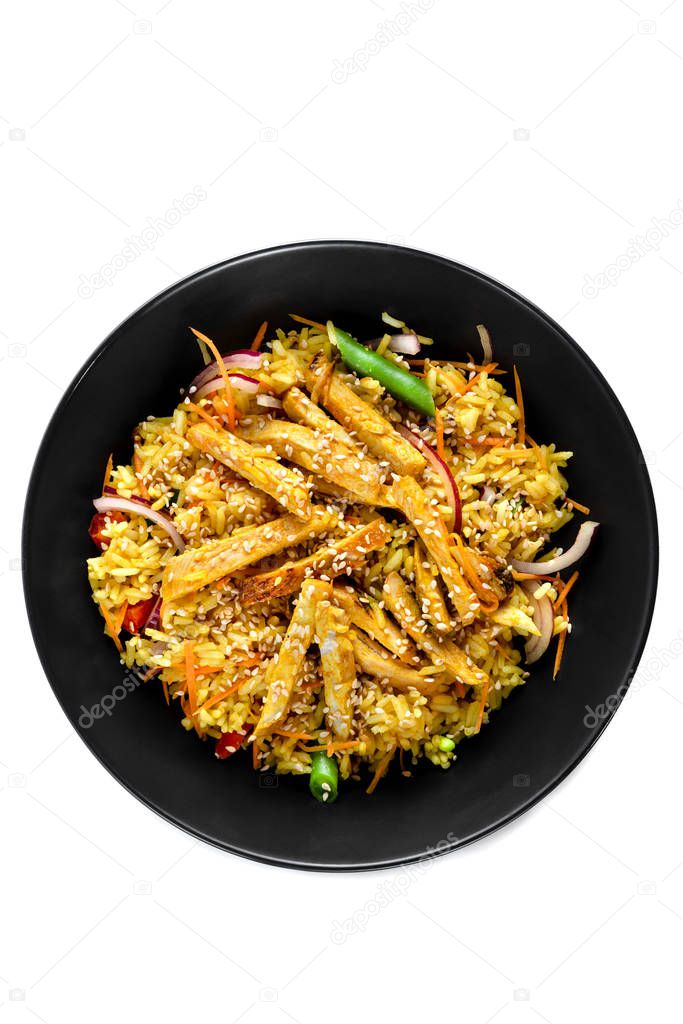 Sliced grilled chicken breast, white rice in sauce, vegetables and sesame seeds in a black plate isolated on white background, top view
