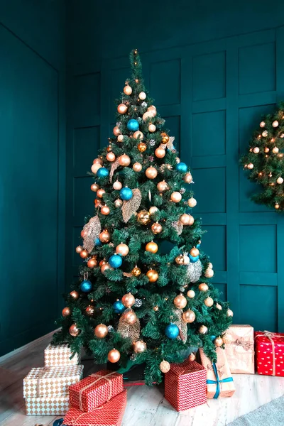 Interior of a beautiful cyan room decorated for Christmas, a lot of gift boxes and presents under a blue fir tree, festive mood atmosphere and concept of New Year — Stock Photo, Image