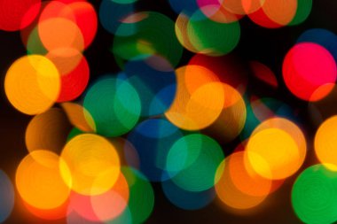 Soyut karnaval ve Noel arkaplanı rengarenk çelenk ışıkları, kırmızı, yeşil, mavi, sarı renkler fotokopi alanı ile