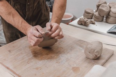 Potter 'ın elleri işe gitmeden önce yoğurur ve nemlendirir. El işçiliği, yaratıcılık ve sanat kavramı.