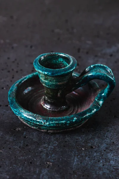 Zabytkowy ceramiczny świecznik w kolorze turkusowym na szarym tle cementu, starożytny obiekt przeznaczony do świec reprezentujących wykwintne dekoracji domu, zdjęcie pionowe — Zdjęcie stockowe