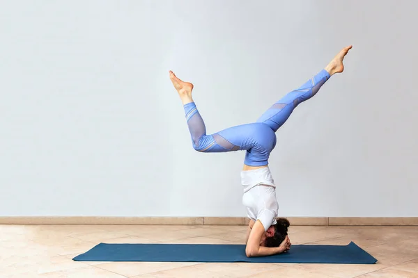 Jógi lány áll Adho Mukha Vrksasana gyakorlat. Egy nő fejen állva gyakorol a jóga stúdióban. Lefelé néző Tree Pose, másolás tér — Stock Fotó