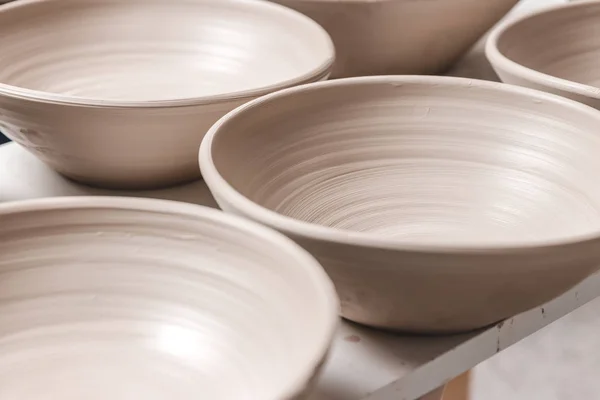 Raw ceramic bowls made from white clay on the potter's wheel circle waiting for putting in the pottery kiln, concept of manual work, creativity and art, horizontal photo — 스톡 사진