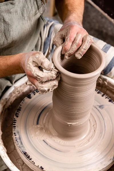 Potter membuat pot kendi tanah liat putih pada roda pembuat tembikar lingkaran di studio, konsep kreativitas dan seni, foto vertikal — Stok Foto