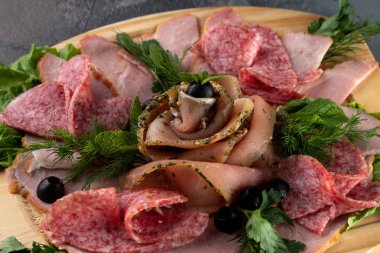 salam, domuz pastırması, maydanozlu jambon ve odun kesme tahtasında zeytin gibi dilimlenmiş makro manzara.