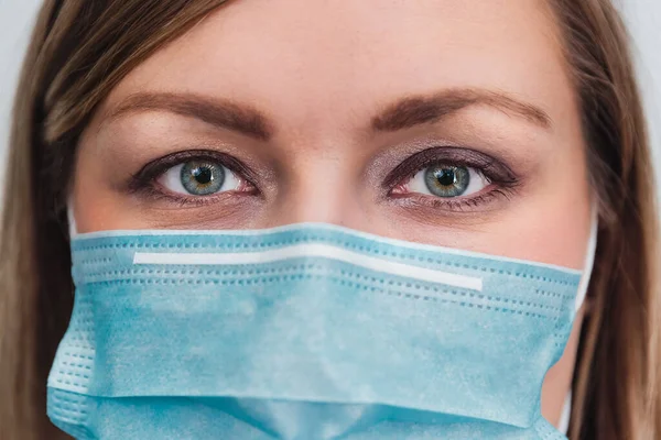 Woman wearing protection medicine mask. Female face of medical staff close-up. Preventive gear against coronavirus