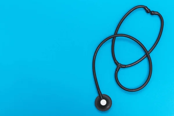 Black stethoscope isolated on a blue medicine background with copy space, concept of health care