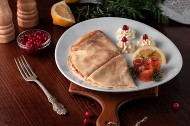 Kırmızı balıklı, limonlu ve yaban mersinli gözlemeler, restoranda Rus usulü servis edilen masa, Rus festivali yemeği masenitsa veya shrovetide konsepti.