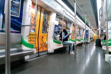 Koronavirüs yüzünden maskeli bir adam trende oturuyor.