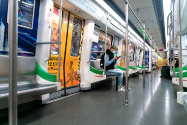 Koronavirüs yüzünden maskeli bir adam trende oturuyor.