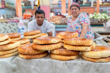 Khujand / Tacikistan-05.18.2020: Tacik pazarında geleneksel yuvarlak buğday ekmeği dolu tezgahın manzarası