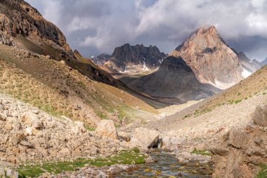 Tacikistan 'daki Fann dağlarında Zmeya zirvesine yakın mavi gökyüzü ve kar dağı manzarası.