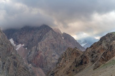 Tacikistan 'daki Fann dağlarında Zmeya zirvesine yakın mavi gökyüzü ve kar dağı manzarası.