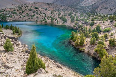 Temiz mavi gökyüzü, kayalık tepeler ve Tacikistan 'daki Fann Dağları' ndaki Alaudin Gölü manzaralı güzel dağ yürüyüşü yolu.