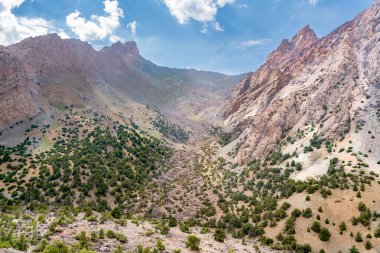 Temiz mavi gökyüzü, kayalık tepeler ve Tacikistan 'daki Fann Dağları' ndaki Alaudin Gölü manzaralı güzel dağ yürüyüşü yolu.