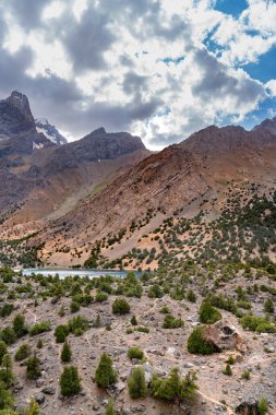 Temiz mavi gökyüzü, kayalık tepeler ve Tacikistan 'daki Fann Dağları' ndaki Alaudin Gölü manzaralı güzel dağ yürüyüşü yolu.
