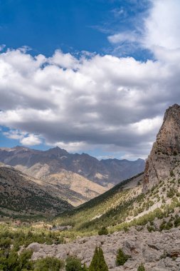 Temiz mavi gökyüzü, kayalık tepeler ve Tacikistan 'daki Fann dağlarındaki taze dağ deresi ile güzel dağ yürüyüşü yolu.