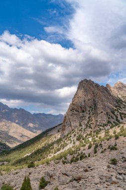 Temiz mavi gökyüzü, kayalık tepeler ve Tacikistan 'daki Fann dağlarındaki taze dağ deresi ile güzel dağ yürüyüşü yolu.