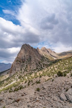 Temiz mavi gökyüzü, kayalık tepeler ve Tacikistan 'daki Fann dağlarındaki taze dağ deresi ile güzel dağ yürüyüşü yolu.