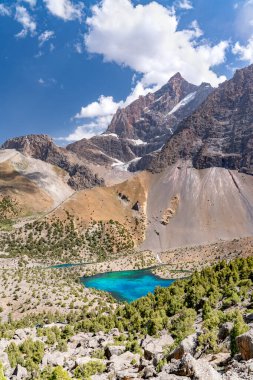 Temiz mavi gökyüzü, kayalık tepeler ve Tacikistan 'daki Fann Dağları' ndaki Alaudin Gölü manzaralı güzel dağ yürüyüşü yolu.