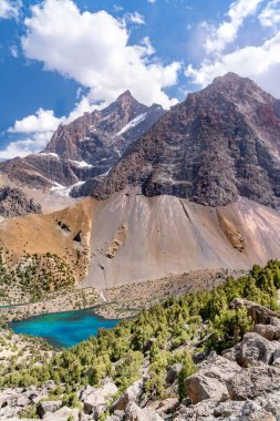 Temiz mavi gökyüzü, kayalık tepeler ve Tacikistan 'daki Fann Dağları' ndaki Alaudin Gölü manzaralı güzel dağ yürüyüşü yolu.